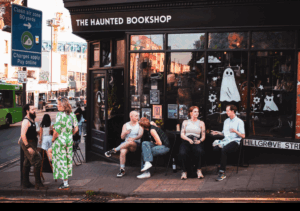 a group of people sitting on chairs outside of the Haunted Bookshop